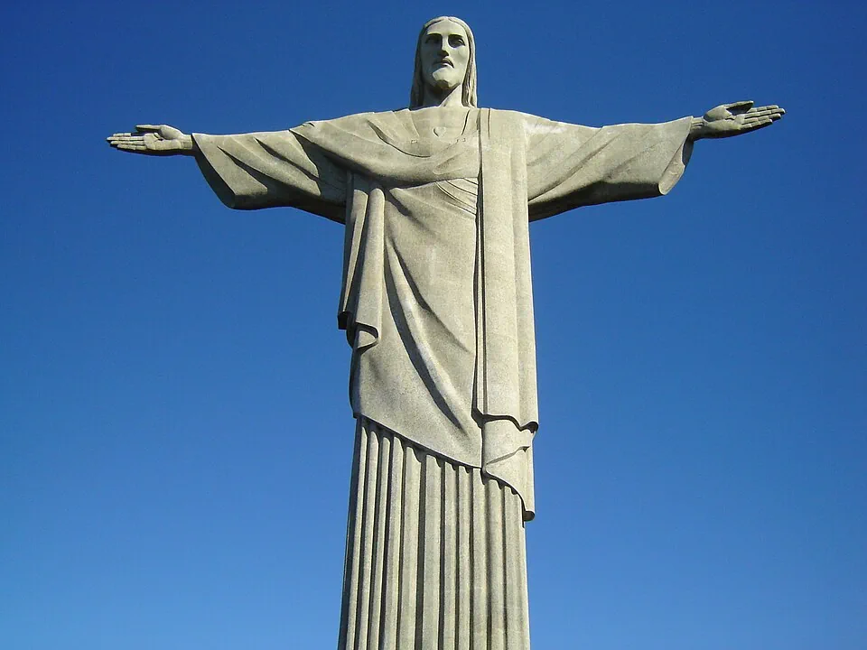 Christ the Redeemer, arms outstretched, against a blue sky